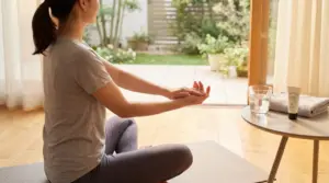 Persona seduta su un tappetino mentre esegue un esercizio mattutino per le mani in casa