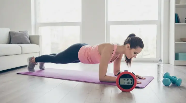 Donna in plank su tappetino a casa con timer da 7 minuti, pesi e bottiglia d’acqua