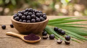 Ciotola di bacche di acai su tavolo in legno con cucchiaio di polvere di acai e foglie verdi