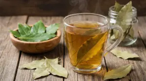 Tazza di bevanda calda all’alloro con foglie di alloro su un tavolo di legno