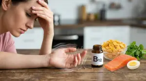 Donna con mano alla fronte e formicolio alla mano accanto a cibi ricchi di vitamina B12