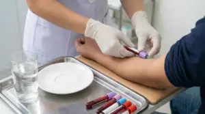 Prelievo del sangue in ambulatorio con bicchiere d’acqua e piatto vuoto, simbolo del digiuno prima delle analisi