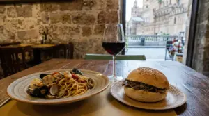 Piatto di pasta ai frutti di mare, panino con carne e bicchiere di vino rosso in un ristorante a Palermo
