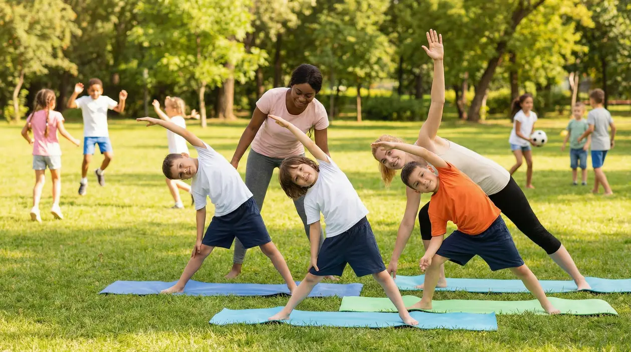 Bambini che fanno stretching su tappetini in un parco con due adulti, attività fisica all’aperto
